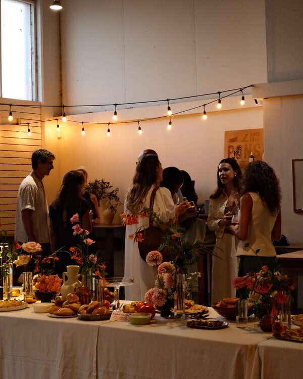 Guests sharing vermut, music, and conversation at the anniversary celebration